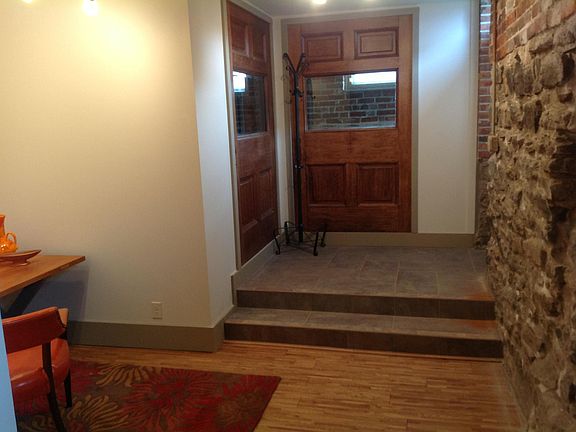 Tiled foyer features two statement wall created from doors salvaged from a period home.