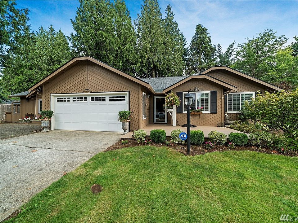 Darling curb appeal with 2 car garage and additional parking for truck/trailer