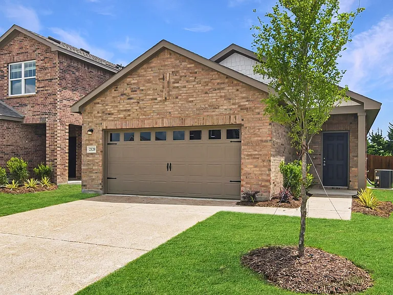 Brick facade exterior with an attached garage featuring decorative hardware