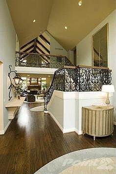 Stunning Entry with cathedral ceilings, hardwood floors, and the beautiful sweeping staircase with custom wrought iron.
