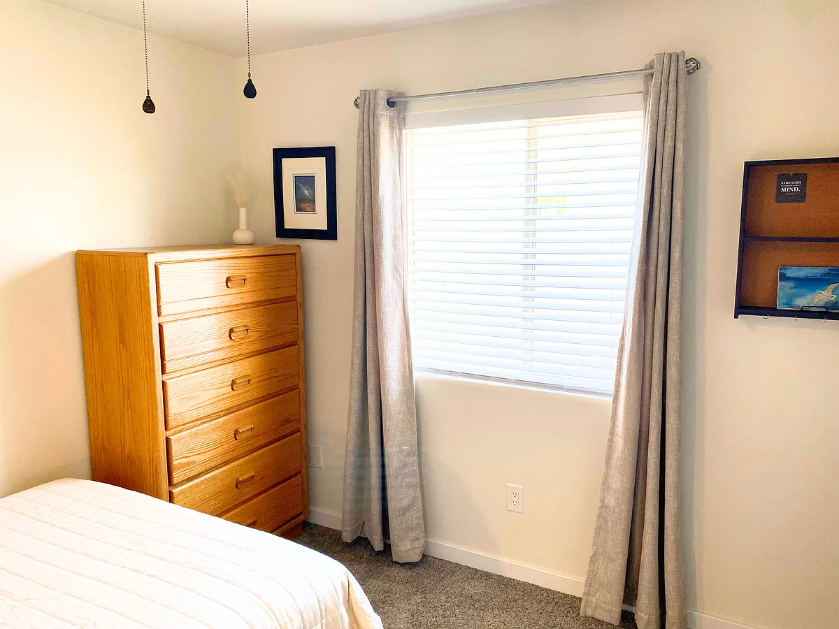 Enjoy privacy with room-darkening blinds and curtains. Ideal for a restful and functional living. - E 24th Ln