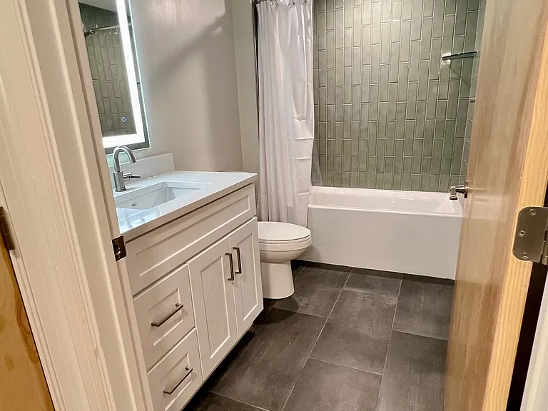 Spacious primary bathroom showing large format porcelain tile.