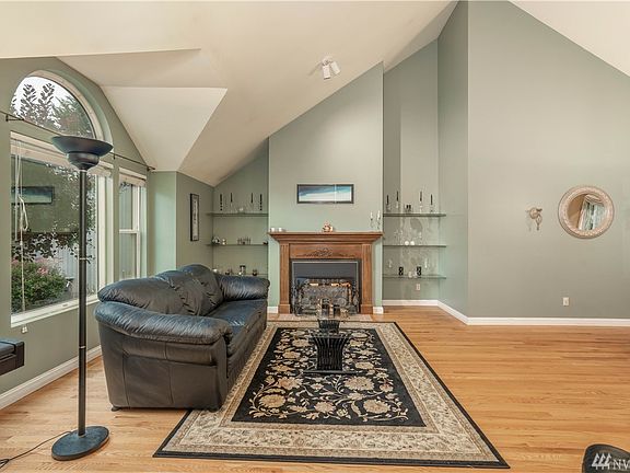 Main living room space right off the entry into the home. A custom built mantel, gas fireplace and look at those vaulted ceilings and natural light spilling in 