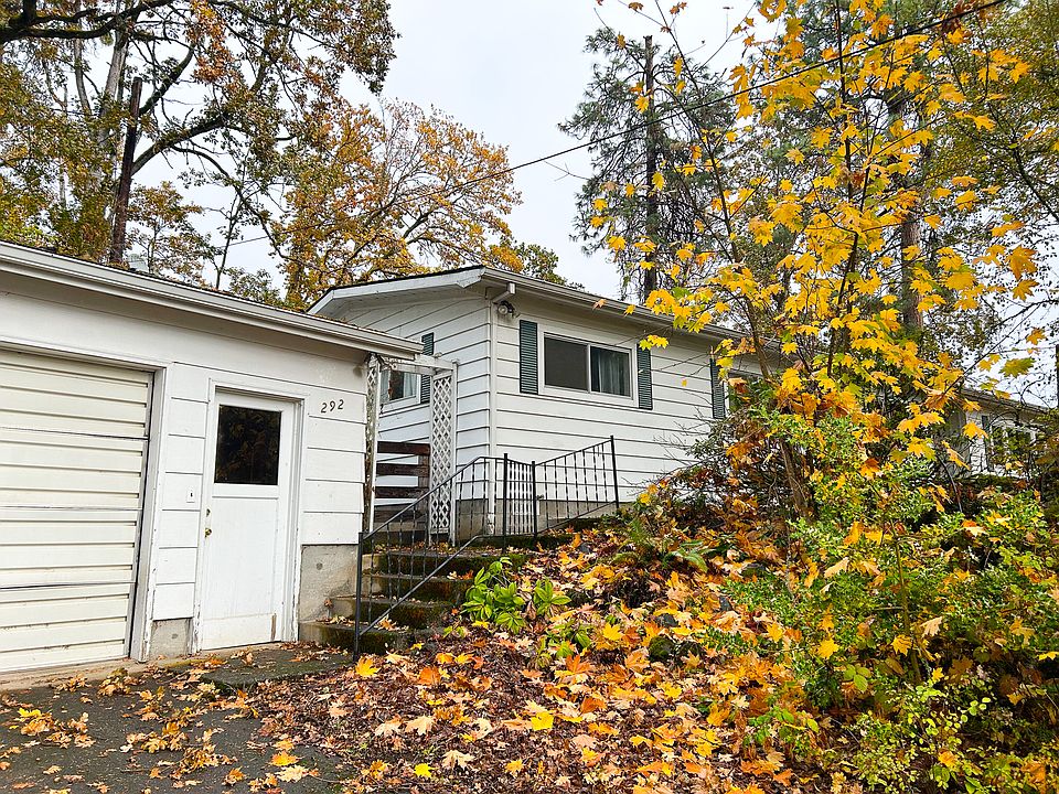 Mature oaks and maples wrap the property in privacy, From the street, the home reveals itself slowly_white siding softened by years of sun and shade, a gentle stairway that leads you upward into the treetops and the front door.