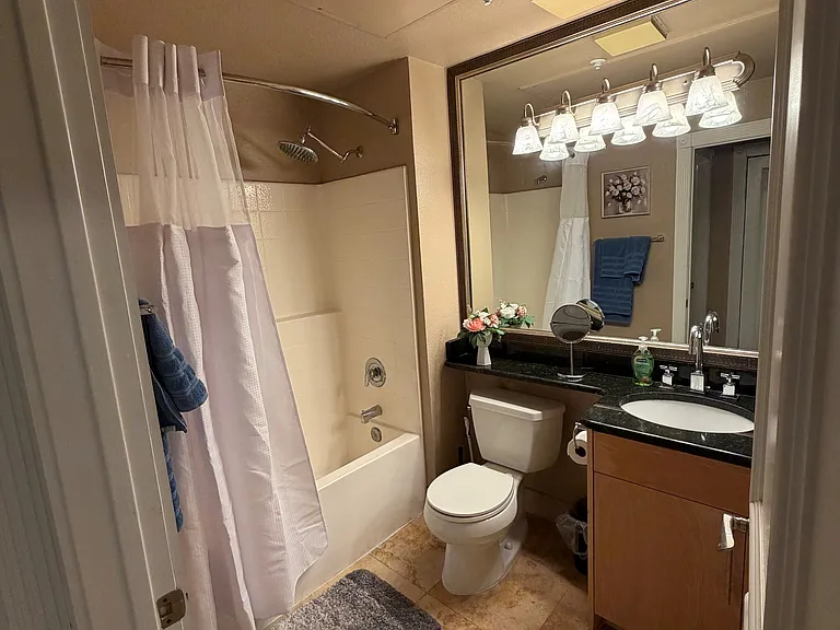 Clean full size bathroom featuring a bathtub / shower combination, fresh towels, and essential amenities for a comfortable stay.