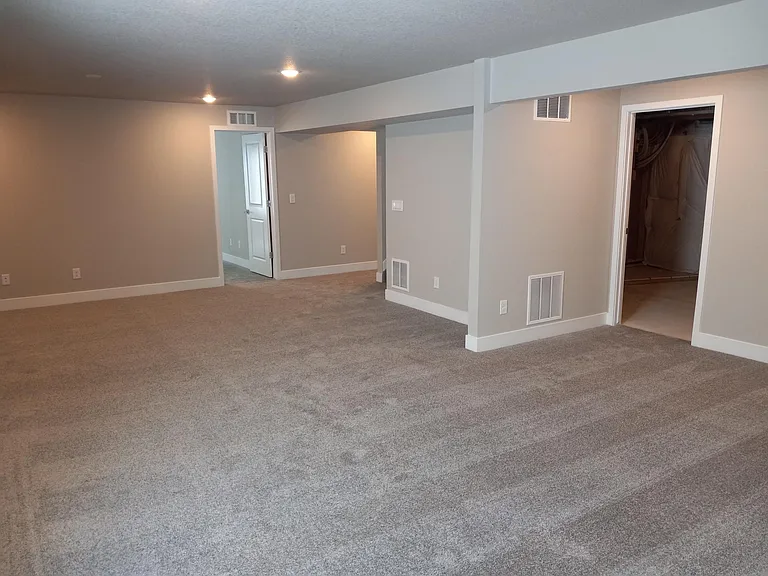 Rec Room: On the right is the doorway to the Utility/Storage room. In the background is Bedroom 3 doorway and hallway to other bedrooms and bath.