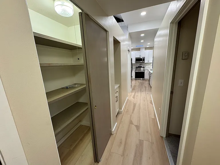 Hallway from primary bedroom towards kitchen. Directly to the left (not pictured) is the back door that leads to the alley where the parking is