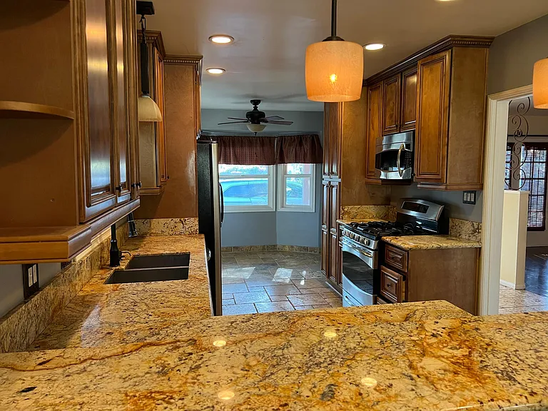 Newer Professional Kitchen with Granite, Travertine Stone Tile tand Stainless steel appliances including a convection oven.