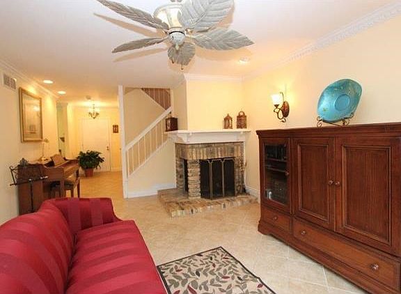 Living room with woodburning fireplace, brick surround and wood mantle.