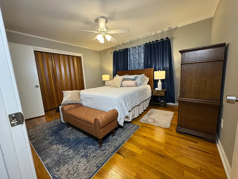 Primary bedroom has a queen-size bed with blackout curtains and a dedicated bathroom with shower