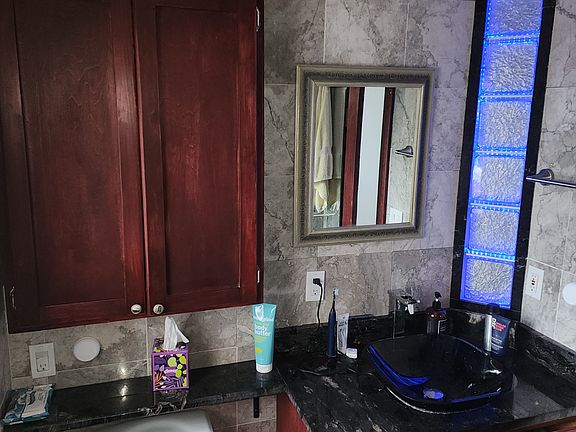 Wall cabinet is 12" deep. Custom built vanity has 4 drawers & a compartment for storage.