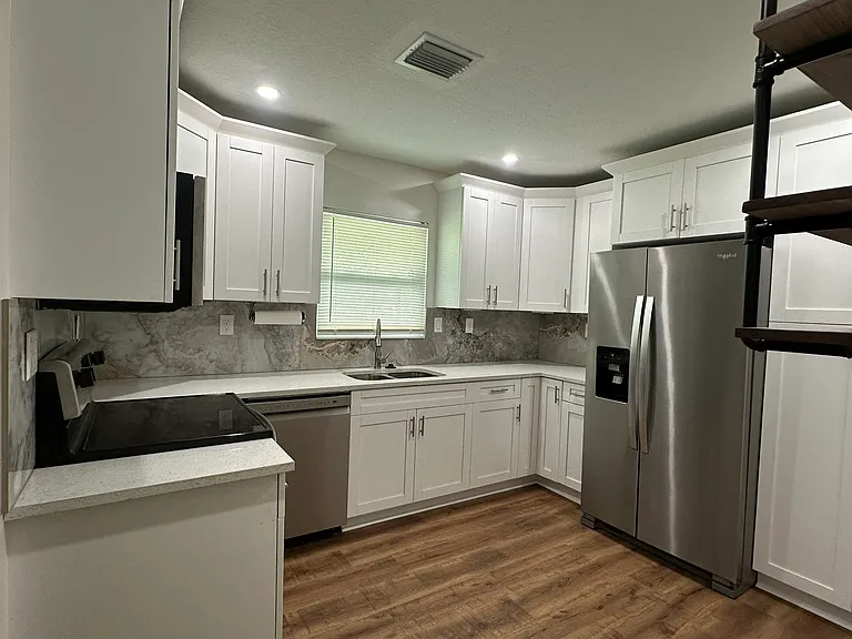 quartz countertops, newish stainless steel appliances, double sink, plenty of cabinet space