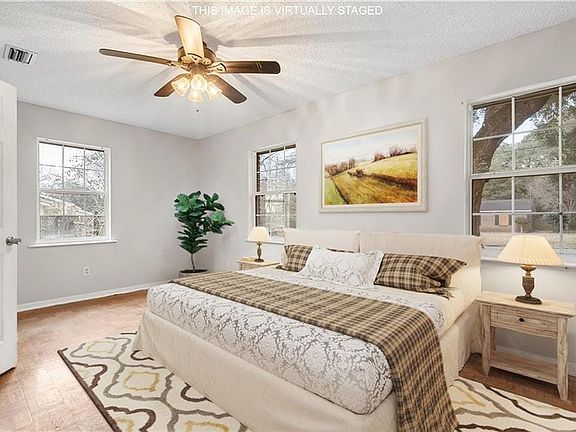 Bedroom featuring a textured ceiling, ceiling fan, visible vents, and baseboards