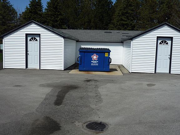 Trash bin and storage shed (shed contains individual locked rooms for each unit -- for example, unit 203 has its own padlocked room within the shed)