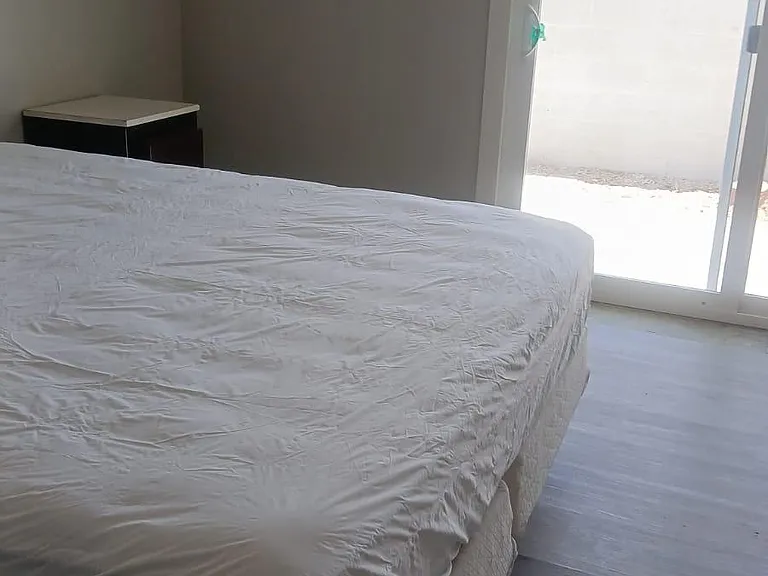 Bedroom with sliding glass doors that open to a private outdoor area, plus space for a bed and nightstand.