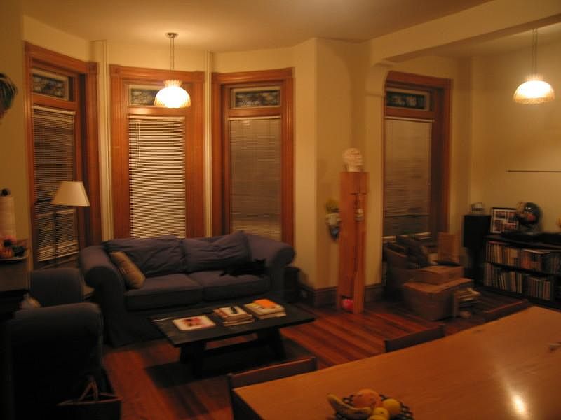Past picture taken at night of the living room with view of the 4 stained glass transom windows and capice shell hanging lights.