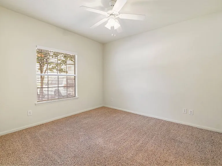 Bright bedroom with a ceiling fan at Stonehaven Apartments in Houston, TX