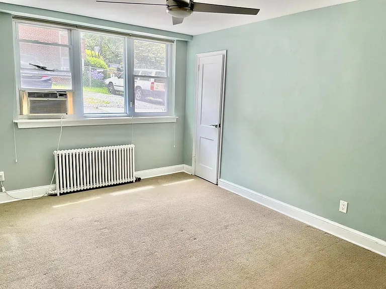 Bedroom with walk-in closet, carpet, and ceiling fan
