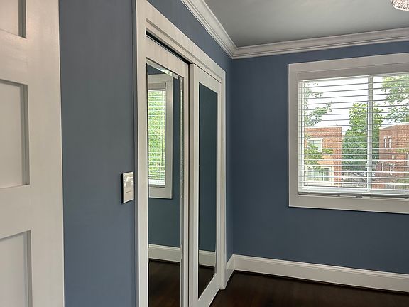 Spacious primary bedroom with large reach in closet and mirrored closet doors