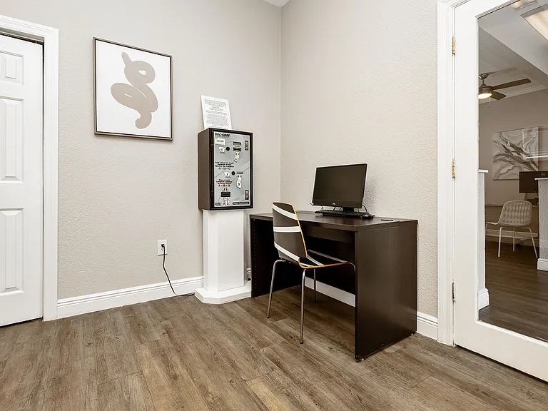 Elegant and cozy office nook with a minimalist desk, chic computer setup, and modern art, perfect for a productive work environment.