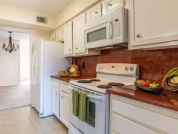 Rich looking quartz counter tops in the kitchen with recent stove, microwave and fridge.
