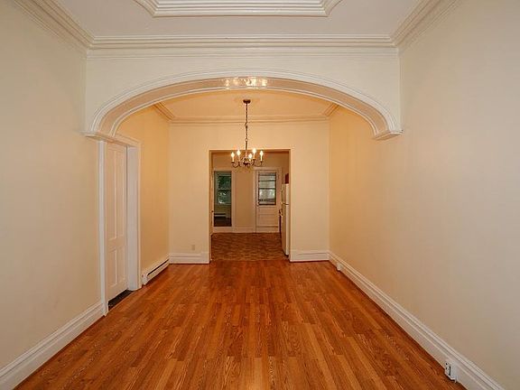 Main living space upon entry, with view into the kitchen. (2016 picture. Updates since: new light fixtures, light grey paint in living room, blue paint in dining room, new built-in shelves in back of kitchen).
