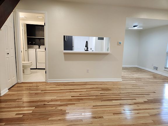 living room looking at half bath/laundry, kitchen + dining area.