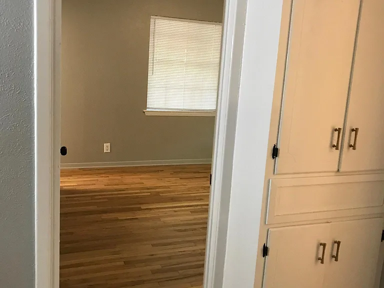 Hall storage cabinet and entrance to primary bedroom