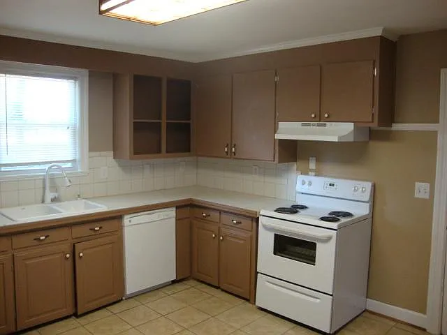 Kitchen. Tiled floor. Window view of backyard.