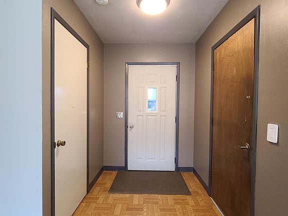 entry way Main entrance in middle, door to garage on right, coat, shoes, board game closet door on left.