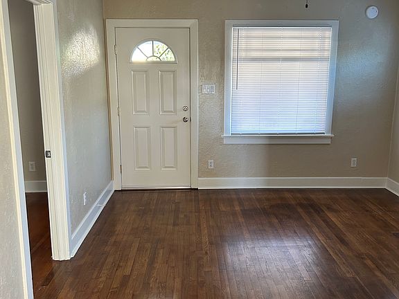Front Door of Living Room with Oak Hardwood Floors & Ceiling Light & Fan.