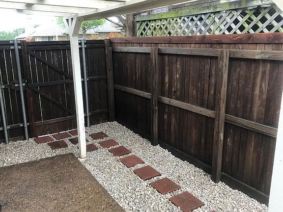 Newly stained fence surrounding side patio area and back yard.