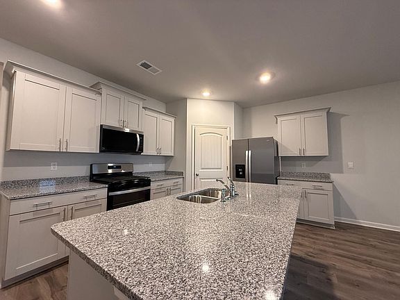 Granite Countertops, Stainless Steal Appliances and overview of breakfast area, living room and covered porch