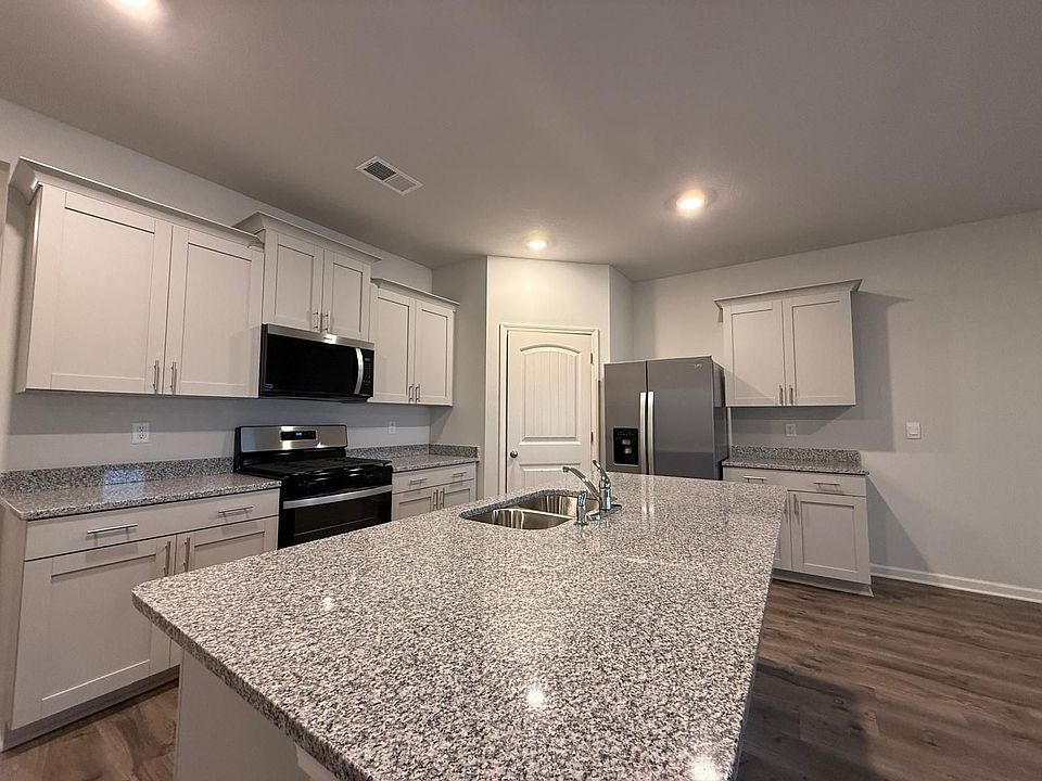 Granite Countertops, Stainless Steal Appliances and overview of breakfast area, living room and covered porch