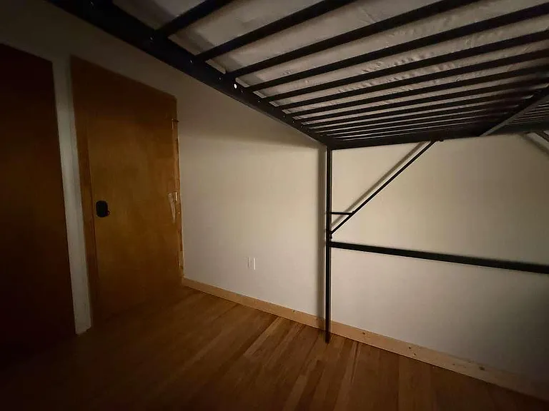 Private room with durable flooring and space for a bed setup, featuring a solid door for added privacy.