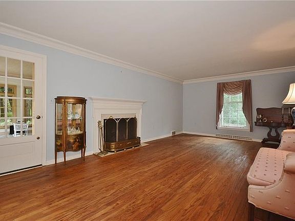Gleaming hardwood floors in expansive living room which boasts a fireplace.