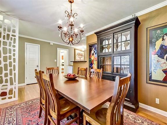 The dining room features a unique wood divider and transitional chandelier.