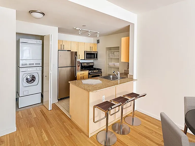 Classic Package kitchen with beige granite countertop, white subway tile backsplash, oak cabinetry, stainless steel appliances, and tile flooring