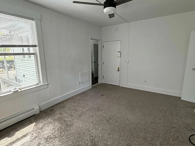 Main room is 160 sq feet, corner of the building with lots of natural light. View of interior door, and bathroom door.