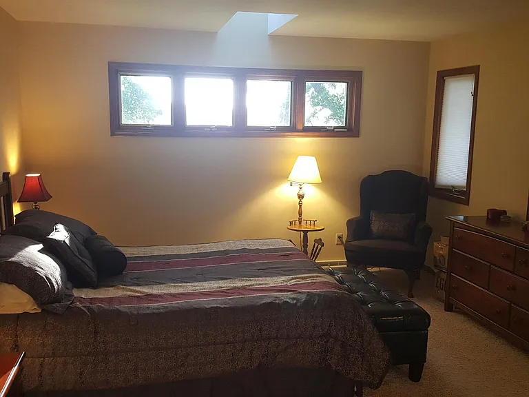Spacious primary bedroom with multiple windows and warm natural light.