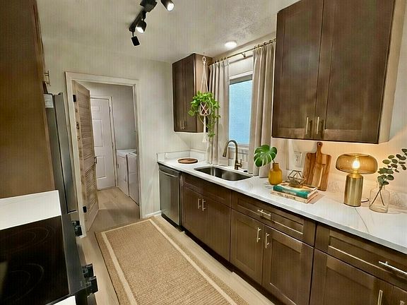 Completely remodeled kitchen with brand new cabinets, all new top of the line appliances, track lighting, Calcutta stone countertops, gold pulls and faucet, large, extra deep sink, dishwasher. Leading into large laundry room with brand new washer/dryer.