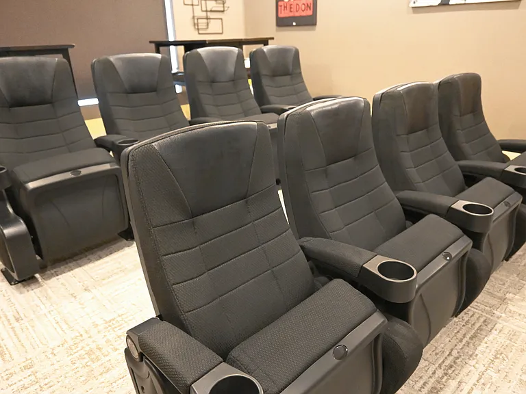 Theater chairs with cupholders in the clubhouse at The Sterling Kearney.