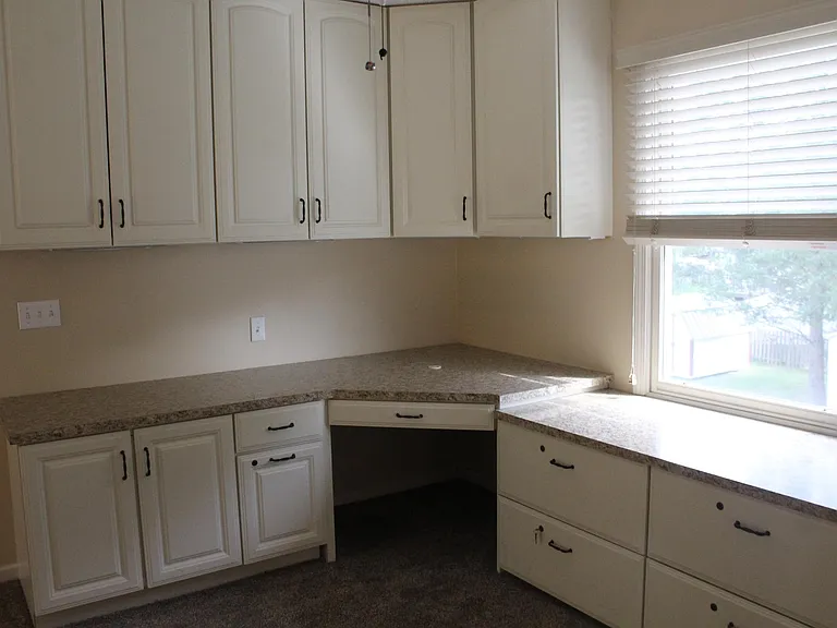 Loft with built-in desk and cabinets