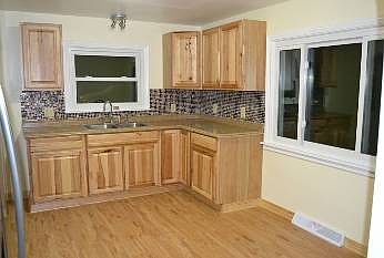 The kitchen is totally new.  It has Hickory cabinets, Neutral paint and counter tops.  New fixtures & windows.  The glass backsplash adds extra character to the room. 