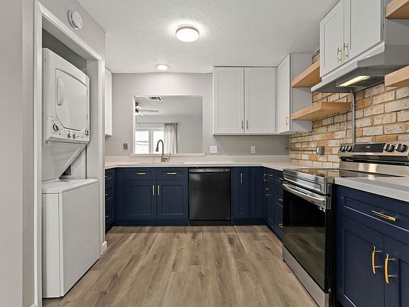 kitchen view of washer-dryer, sink, dishwasher, stove