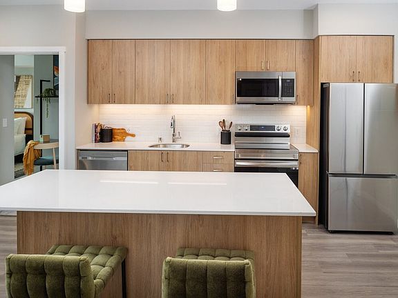 Kitchen with oak cabinetry, stainless steel appliances, granite countertops, and hard surface flooring