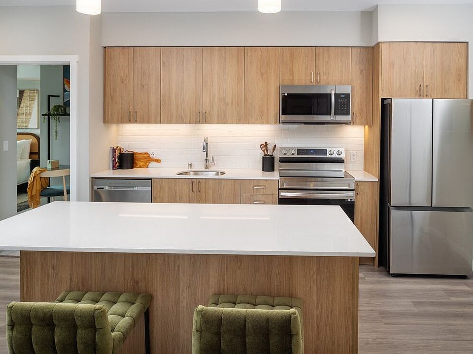 Kitchen with oak cabinetry, stainless steel appliances, granite countertops, and hard surface flooring