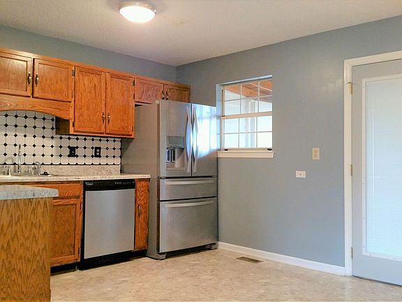 View of the kitchen entering from living area. Door leading to screened porch and back yard.