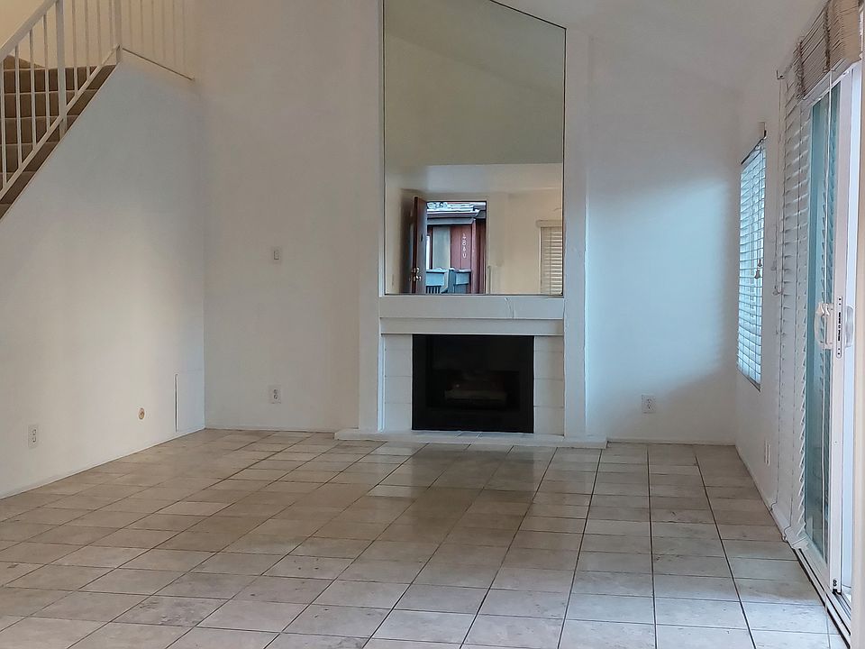 Spacious living room with fireplace and large mirror.