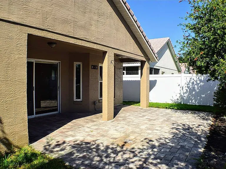 Our back patio with cobblestone brick and vinyl fence around the home